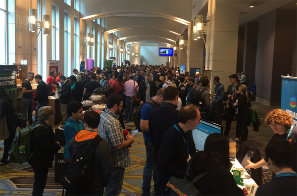 Photo of WordCamp US showing the large crowd in the sponsors area during a break.